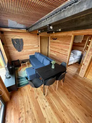 a room with a table and a couch and a bed at Modrzewiowe Domki w Koszarawie in Koszarawa