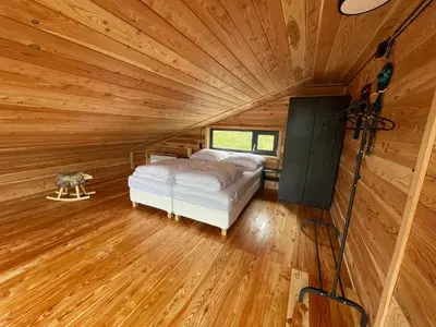 a bedroom in a log cabin with a bed in it at Modrzewiowe Domki w Koszarawie in Koszarawa
