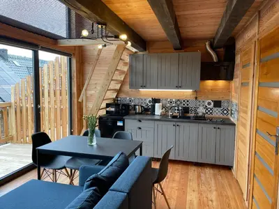 a kitchen and living room with a couch and a table at Modrzewiowe Domki w Koszarawie in Koszarawa