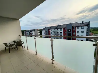 a balcony with a table and chairs and buildings at K&M Apartament Panorama in Bochnia