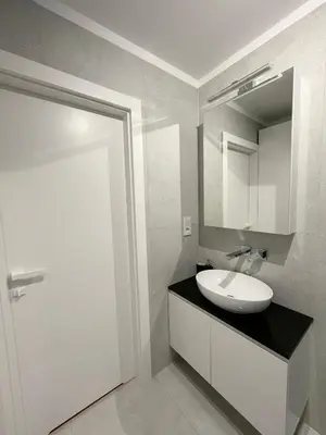 a white bathroom with a sink and a mirror at K&M Apartament Panorama in Bochnia