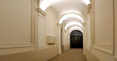a hallway with arched ceilings and a black door at 777 Apartaments in Kraków