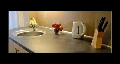 a kitchen counter with a sink and a knife holder at 777 Apartaments in Kraków