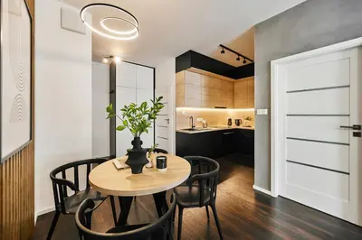 a dining room with a table and chairs and a kitchen at Main Station Art Apartment in Kraków