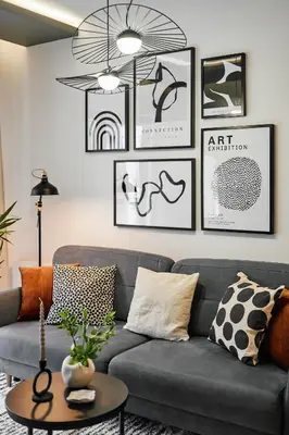 a living room with a gray couch and pictures on the wall at Main Station Art Apartment in Kraków