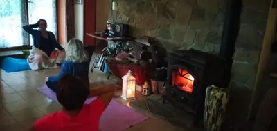 a group of people sitting in front of a fireplace at Agroturystyka Millerówka in Kamionka Mała