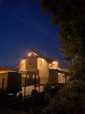 a white house with lights on the roof at night at MARMI Noclegi in Golczowice