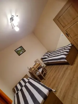 a room with two beds and a wooden floor at MARMI Noclegi in Golczowice