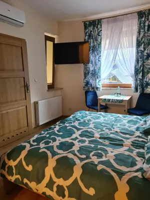 a bedroom with a bed and a table and a window at MARMI Noclegi in Golczowice