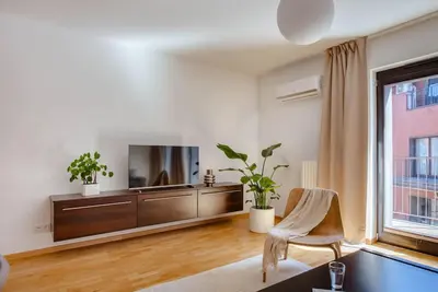 a living room with a television and a chair at Wygodny Apartament Przy Dworcu in Kraków