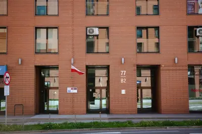 a red brick building with doors and windows at Wygodny Apartament Przy Dworcu in Kraków