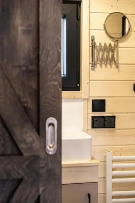 a bathroom with a sink and a door at Staymoovers - Tinyhouse Zator in Zator