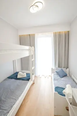 two bunk beds in a white room with a window at Scandilook Apartament in Zator