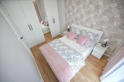 a small bedroom with a bed with pink pillows at Scandilook Apartament in Zator