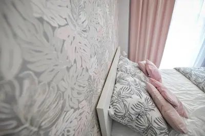 a bedroom with a bed and a wall with a curtain at Scandilook Apartament in Zator