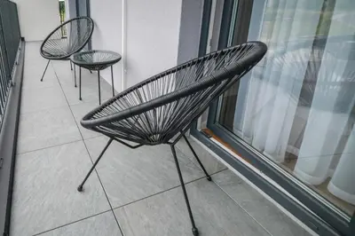 two black chairs sitting on a balcony next to a window at Scandilook Apartament in Zator