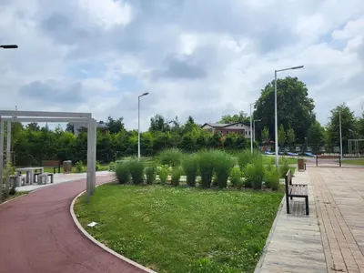 a park with benches and grass and street lights at Scandilook Apartament in Zator