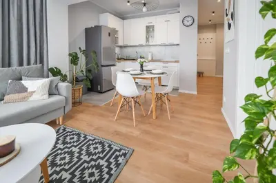 a kitchen and living room with a table and chairs at Scandilook Apartament in Zator