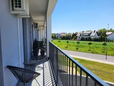 a balcony with two chairs and a view of a yard at Scandilook Apartament in Zator