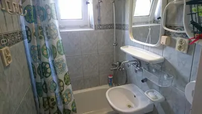 a bathroom with a sink and a shower curtain and a toilet at 2d likwi klimatyzacja mieszkanie z kuchnią normalne dwupokojowe in Kraków