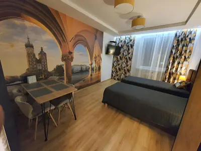 a bedroom with a bed and a table and a painting at Komfortowo i cicho - Apartament in Kraków