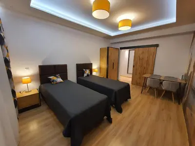 a hotel room with two beds and a table and a table at Komfortowo i cicho - Apartament in Kraków