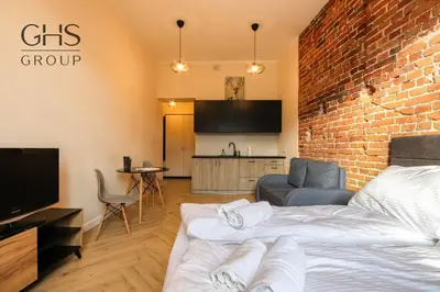 a room with two beds and a brick wall at Apartament w zabytkowej kamienicy, Strzelecka 19 in Kraków