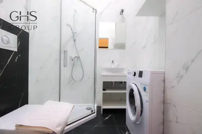 a bathroom with a shower and a washing machine at Apartament w zabytkowej kamienicy, Strzelecka 19 in Kraków