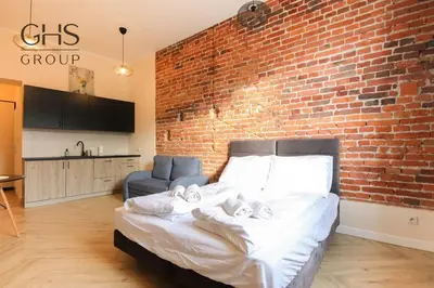a bedroom with a brick wall and a bed at Apartament w zabytkowej kamienicy, Strzelecka 19 in Kraków