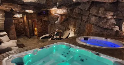 a bathroom with a bath tub in a cave at Loft Na Stodole z jaskinią SPA - Osada Jaworzyny in Zawadka