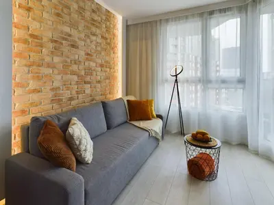 a living room with a blue couch and a brick wall at City Centre & Modern Quiet Apartment with Parking by Renters Prestige in Kraków