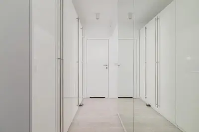 an empty corridor with white doors and a tile floor at City Centre & Modern Quiet Apartment with Parking by Renters Prestige in Kraków