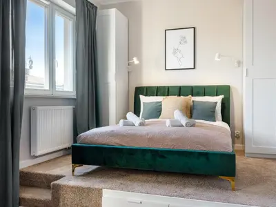 a bedroom with a green bed and a window at Tyzenhauz Apartments Rakowicka Street in Kraków