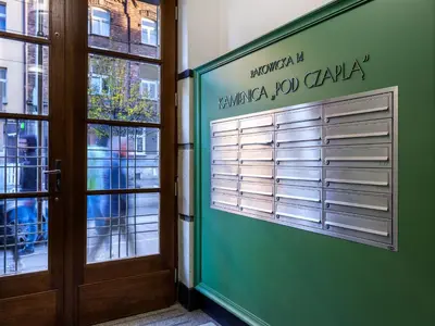 a green door with a sign on the side of a building at Tyzenhauz Apartments Rakowicka Street in Kraków