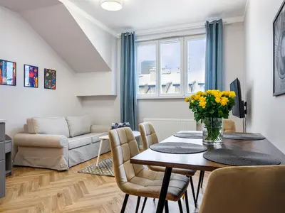 a living room with a table and chairs and a couch at Tyzenhauz Apartments Rakowicka Street in Kraków