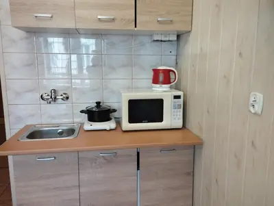 a kitchen counter with a microwave and a sink at Apartment Kazimierz Rzeszowska in Kraków