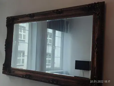 a mirror on a wall with a reflection of a window at Apartment Kazimierz Rzeszowska in Kraków