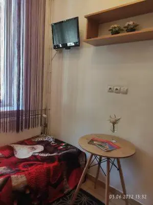 a room with a bed and a table and a television at Apartment Kazimierz Rzeszowska in Kraków