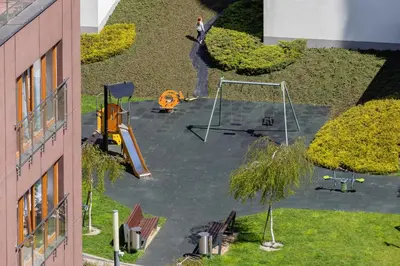 a person standing in a park with a playground at Grzegórzki Park Unique Apartment Cracow by Renters Prestige in Kraków
