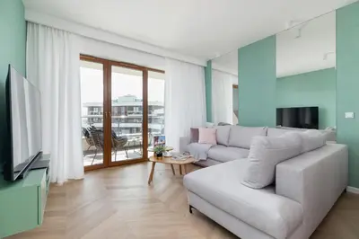 a living room with a couch and a television at Grzegórzki Park Unique Apartment Cracow by Renters Prestige in Kraków