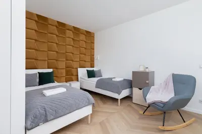 a bedroom with a bed and a chair at Grzegórzki Park Unique Apartment Cracow by Renters Prestige in Kraków