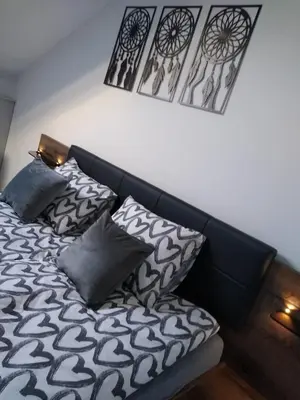 a bedroom with a bed with black and white pillows at Apartamenty MAX blisko Energylandia in Ryczów