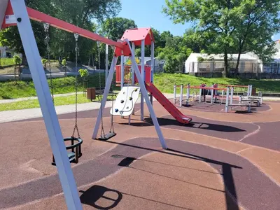 a playground with a red slide and swings at Apartamenty MAX blisko Energylandia in Ryczów