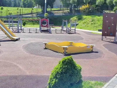 a playground with a yellow slide in a park at Apartamenty MAX blisko Energylandia in Ryczów
