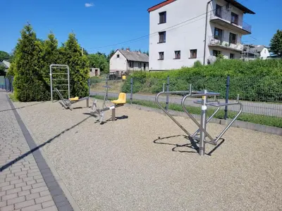 a playground with three swings and a slide at Apartamenty MAX blisko Energylandia in Ryczów