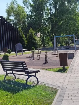 a park bench in a park with a playground at Apartamenty MAX blisko Energylandia in Ryczów
