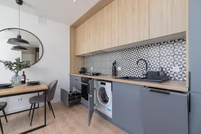 a kitchen with a washing machine and a washer and dryer at Modern Apartment Grzegórzeckie Roundabout Cracow by Noclegi Renters in Kraków