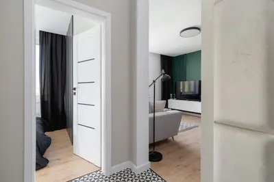 a room with a white door and a living room at Modern Apartment Grzegórzeckie Roundabout Cracow by Noclegi Renters in Kraków