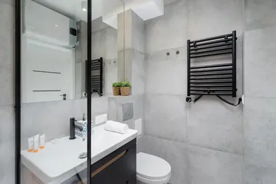 a bathroom with a white sink and a toilet at Modern Apartment Grzegórzeckie Roundabout Cracow by Noclegi Renters in Kraków