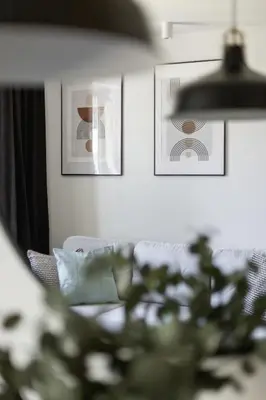a living room with a couch and pictures on the wall at Modern Apartment Grzegórzeckie Roundabout Cracow by Noclegi Renters in Kraków